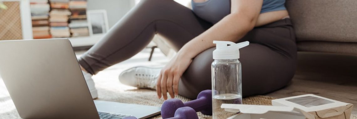 Plus size woman exercising at home with purple dumbbells, showcasing healthy lifestyle.