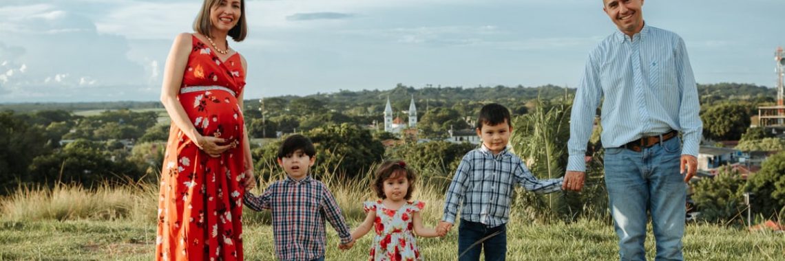 A joyful family with pregnant mother and children enjoying a sunny day in La Dorada, Colombia.